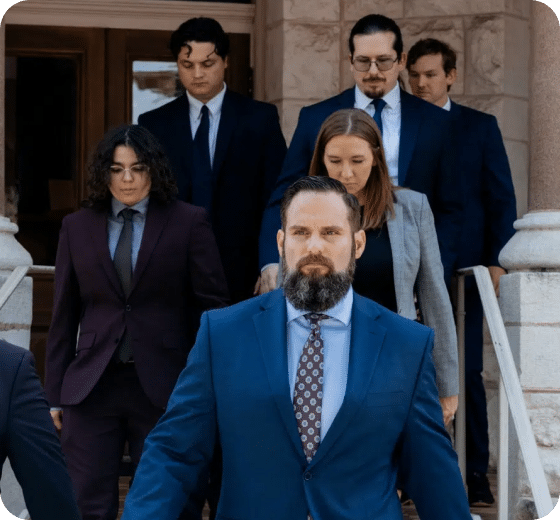Group of Professionals Exiting a Building A group of six professionals in formal attire walking down steps outside a building.